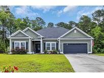 Charming single-story home with green siding, neat landscaping, and a two-car attached garage at 321 Sanctuary Ct., Myrtle Beach, SC 29588