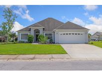 Well-maintained home with a manicured lawn and an attached two-car garage on a sunny day at 357 Southern Breezes Circle, Murrells Inlet, SC 29576