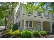 Charming two-story townhome featuring a covered porch with rocking chairs and meticulously landscaped surroundings at 4901 N Market St., North Myrtle Beach, SC 29582