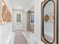 Bright entryway with decor, light wood-look floors, leading to a white door with sidelights at 506 Haven View Way, Murrells Inlet, SC 29576