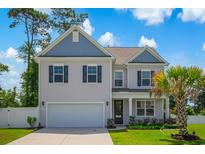 Charming two-story home featuring a two-car garage, manicured lawn, and inviting entrance at 547 Pacific Commons Dr., Surfside Beach, SC 29575