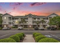 Three-story condo with white balconies, palm trees, and well-maintained landscaping against a vibrant sunset sky at 6015 Catalina Dr. # 634, North Myrtle Beach, SC 29582