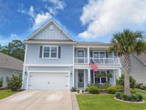 Charming two-story home with a welcoming front porch, a two-car garage, and well-maintained landscaping at 748 Old Murrells Inlet Rd., Murrells Inlet, SC 29576
