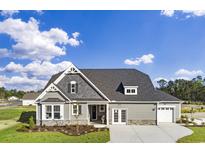 Charming two-story home featuring gray siding, stone accents, and a well-manicured front lawn under a bright blue sky at 866 Fowler Rd., Conway, SC 29526