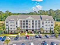 Beautiful condo exterior with ample parking, manicured landscaping, and building with multiple units at 901 Knoll Shores Ct. # 304, Murrells Inlet, SC 29576