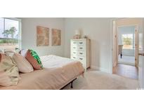 Bright bedroom featuring soft carpet, neutral walls, large window, and a stylish white dresser for ample storage at 9734 Indigo Creek Blvd., Murrells Inlet, SC 29576