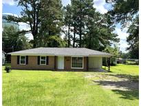 Charming brick home with a well-manicured front yard, mature trees, and a covered carport at 109 S Maple Ave., Andrews, SC 29510