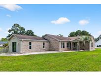 Charming single-story brick home featuring a lush green lawn and mature trees at 131 Pine Lake Circle, Ocean Isle Beach, NC 28469