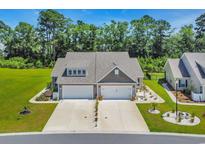 Charming home with two-car garages, a landscaped front yard, and a well-manicured lawn at 1520 Jardine Loop, Little River, SC 29566