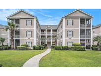 Beautiful condo building with a well-manicured lawn, lush landscaping, and inviting walkway at 2000 Cross Gate Blvd. # 202, Surfside Beach, SC 29575