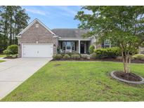 Charming single Gathering home with brick and vinyl siding, manicured lawn and front porch bench at 2010 Chattooga Ct., Myrtle Beach, SC 29588