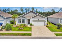 Charming single-story home boasts a well-manicured lawn and a welcoming two-car garage at 2882 Ophelia Way, Myrtle Beach, SC 29577