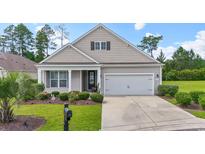 Charming single-story home featuring a well-manicured lawn, a two-car garage, and a welcoming front porch at 308 Firenze Loop, Myrtle Beach, SC 29579