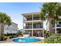 A luxurious brick house featuring a private pool, hot tub, and multiple balconies with views at 337 St. Julian Ln., Myrtle Beach, SC 29579