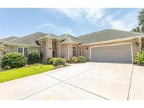 Charming single-story brick home featuring a spacious driveway and well-maintained landscaping at 413 Sea Vista Ln., North Myrtle Beach, SC 29582