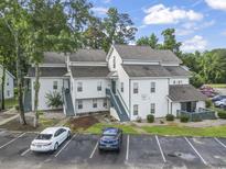 Well-maintained condo complex features classic white siding and neatly painted stairs in a desirable neighborhood at 4344 Spa Dr. # 605, Little River, SC 29566