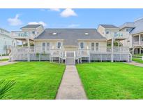Charming beach house with a spacious porch and well-manicured lawn at 4806 S Ocean Blvd., Surfside Beach, SC 29575