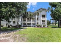 Beautiful condo building featuring classic architecture, balconies, and a lush green lawn with mature trees at 537 White River Dr. # 17C, Myrtle Beach, SC 29579