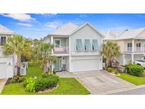 Charming two-story beach home featuring palm trees, a front porch, and a two-car garage at 540 Chanted Dr., Murrells Inlet, SC 29576
