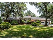Charming brick home featuring manicured landscaping and a welcoming front entrance at 951 Herriott Farms Dr., Georgetown, SC 29440