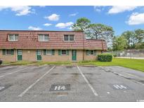 Charming brick condo with green shutters, a red roof, and parking spaces available for residents at 1025 Carolina Rd. # H4, Conway, SC 29526