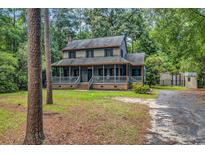 Charming two-story home with a welcoming front porch and beautifully wooded surroundings, inviting relaxation at 1072 Chelsey Circle, Conway, SC 29526
