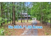 Charming two-story home nestled on a 1.05 acre lot with a long driveway and mature trees at 1072 Chelsey Circle, Conway, SC 29526