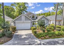 Charming single-story home featuring a manicured lawn and attached two-car garage at 1208 Trisail Ln, North Myrtle Beach, SC 29582