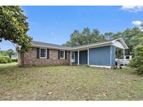 Charming single-story home featuring a brick facade and a covered carport, set on a spacious lot at 169 Ole Maple St., Loris, SC 29569