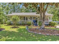 Charming home with a welcoming front porch and lush landscaping at 201 Surrey Ln., Myrtle Beach, SC 29579