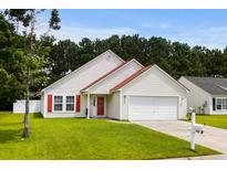 Charming single-Gathering home with attached garage, manicured lawn, and colorful red door and shutters at 221 Tibton Circle, Myrtle Beach, SC 29588