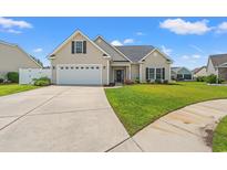 Charming single-story home featuring a well-manicured lawn and a two-car garage on a sunny day at 2885 Desert Rose St., Little River, SC 29566