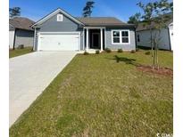 Charming single story home with a well manicured lawn, concrete driveway and an attached two car garage at 289 Eagle Claw Dr., Calabash, NC 28467
