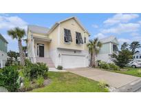 Charming yellow two-story home with a white garage, black shutters and well-manicured lawn at 294 Splendor Circle, Murrells Inlet, SC 29576