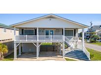 Charming beach house featuring a white picket fence and elevated porch, perfect for enjoying ocean breezes at 3307 Nixon St., North Myrtle Beach, SC 29582
