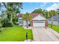 Charming home featuring a well manicured lawn, palm trees, and a two-car garage in a desirable neighborhood at 35 Easter Lilly Ct., Murrells Inlet, SC 29576