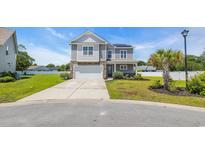 Two-story home featuring gray siding, stone accents, and a well-manicured front yard at 356 Ocean Commons Dr., Surfside Beach, SC 29575