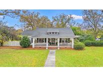 Charming one-story home with a welcoming front porch, landscaped yard, and a classic white picket fence at 3930 West Marion St., Mullins, SC 29574