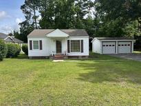 Charming single story home with white siding, brick porch and a two-car detached garage at 404 E Andrews St., Hemingway, SC 29554