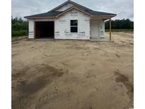 New construction home featuring attached garage and covered entrance, set in a partially cleared lot at 5733 S Highway 41, Marion, SC 29571