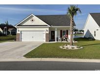 Charming home with a two-car garage, beautifully landscaped yard and inviting front porch seating at 668 Rycola Circle, Surfside Beach, SC 29575