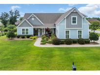 Charming two-story home with a well-manicured lawn and beautiful landscaping at 700 Shell Point Ct., Longs, SC 29568