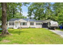 Charming single-story home with well-maintained lawn and a metal roof, surrounded by mature trees at 708 15Th Ave., Conway, SC 29526