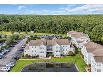 An aerial view of the condo community with a pond, landscaping, and ample parking at 8658 Southbridge Dr. # L, Myrtle Beach, SC 29575