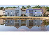 Condo exterior reflecting in the pond, highlighting a serene setting with lush landscaping at 8861 Chandler Dr. # F, Surfside Beach, SC 29575