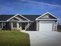Charming single story home featuring tidy lawn, two car garage, and neutral siding under a blue sky at Tbb 2 St. John Rd., Galivants Ferry, SC 29544