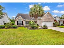 Charming brick home featuring well-manicured lawn and lush landscaping with mature palms in desirable neighborhood at 105 Willow Bay Dr., Murrells Inlet, SC 29576