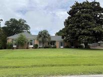 Charming single-story brick home with a spacious front yard and mature trees at 1113 Golf View Dr., North Myrtle Beach, SC 29582