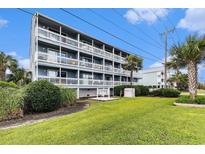 Charming multifamily unit featuring multiple balconies with white railings and lush landscaping at 1210 N Ocean Blvd. # 104, Surfside Beach, SC 29575