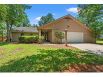 Charming single-story home features lush landscaping, a two-car garage, and welcoming curb appeal at 149 Old Cedar Loop, Pawleys Island, SC 29585